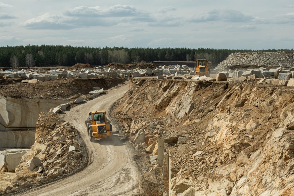 Mining truck moving down road along building area