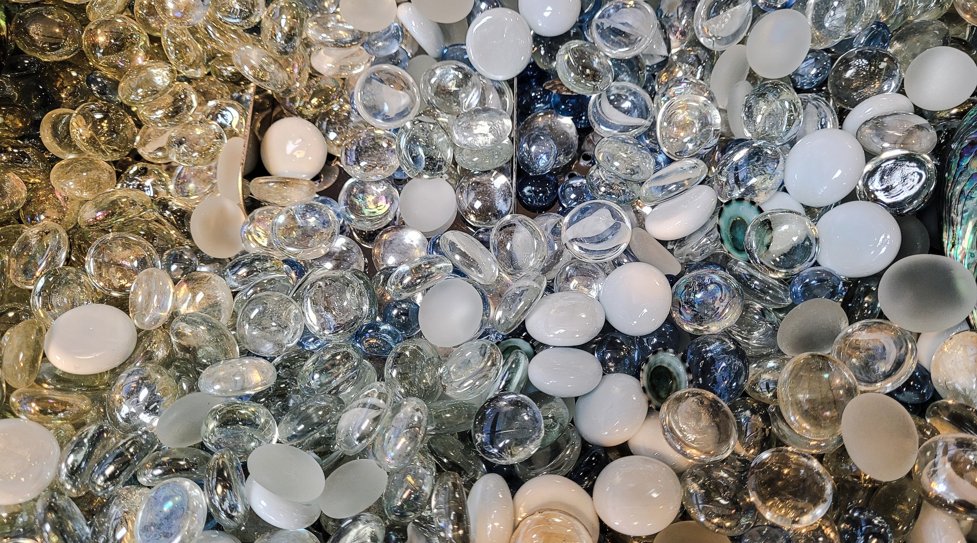 Multi- colored sea glass in a display case in beach store for home decor and landscape ground cover.